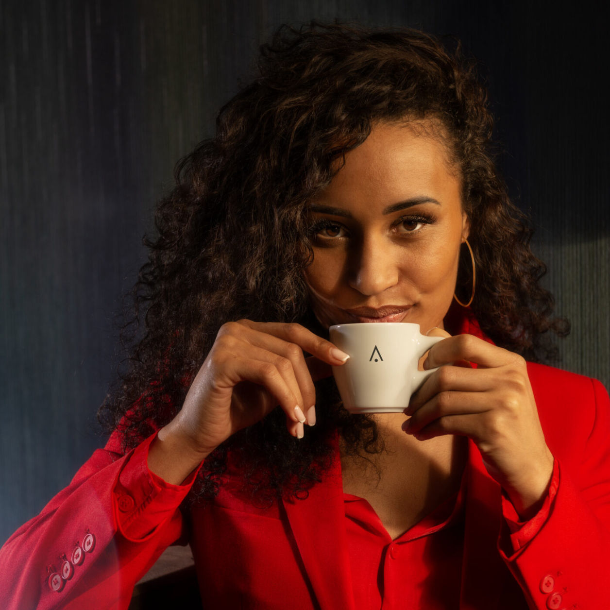 dunkelhäutige Frau mit Tasse am Mund