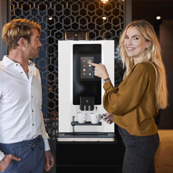 Mann und Frau bedienen eine Kaffeemaschine