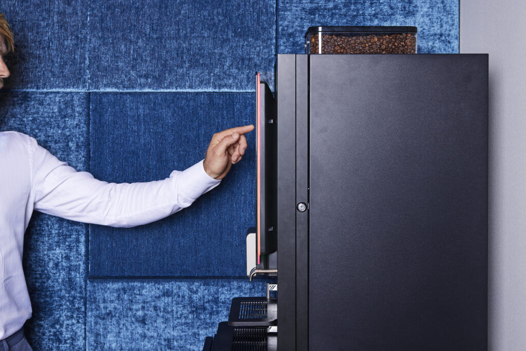 seitliche Ansicht Kaffeemaschine - Hand drückt auf einen Knopf